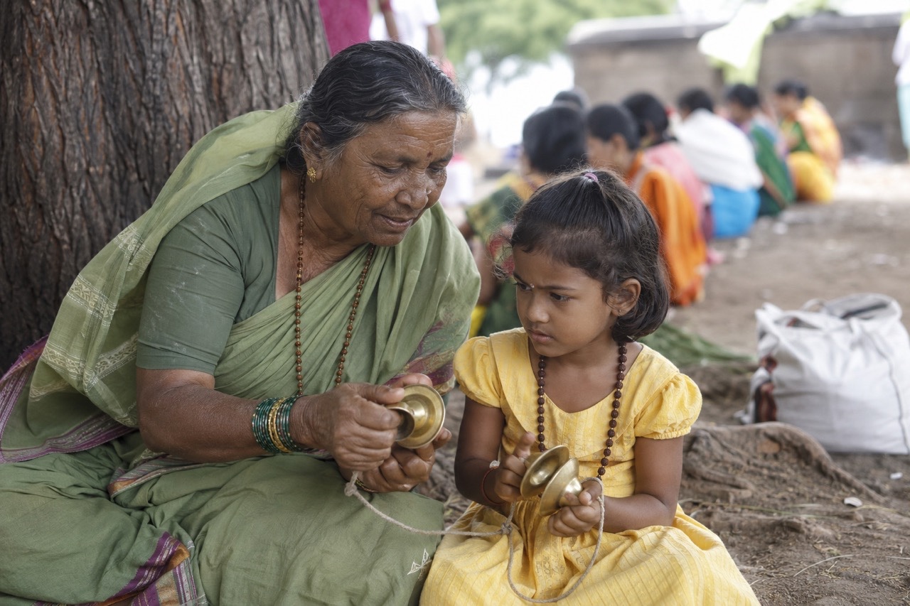 Grandmother Teaching Child to Play Traditional Cymbals | Royalty-Free image | Pixlaris