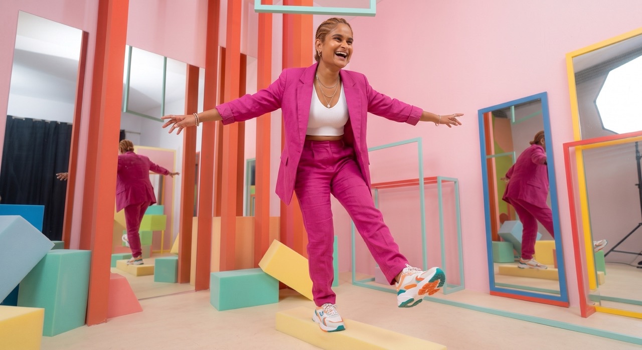 Smiling Indian Woman Balancing in Pink Fashion Suit | Royalty-Free image | Pixlaris