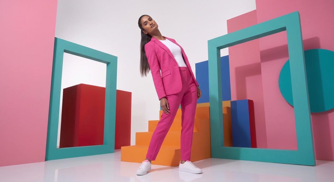 Stylish Woman Leaning in Pink Suit in Color Block Studio | Royalty-Free image | Pixlaris