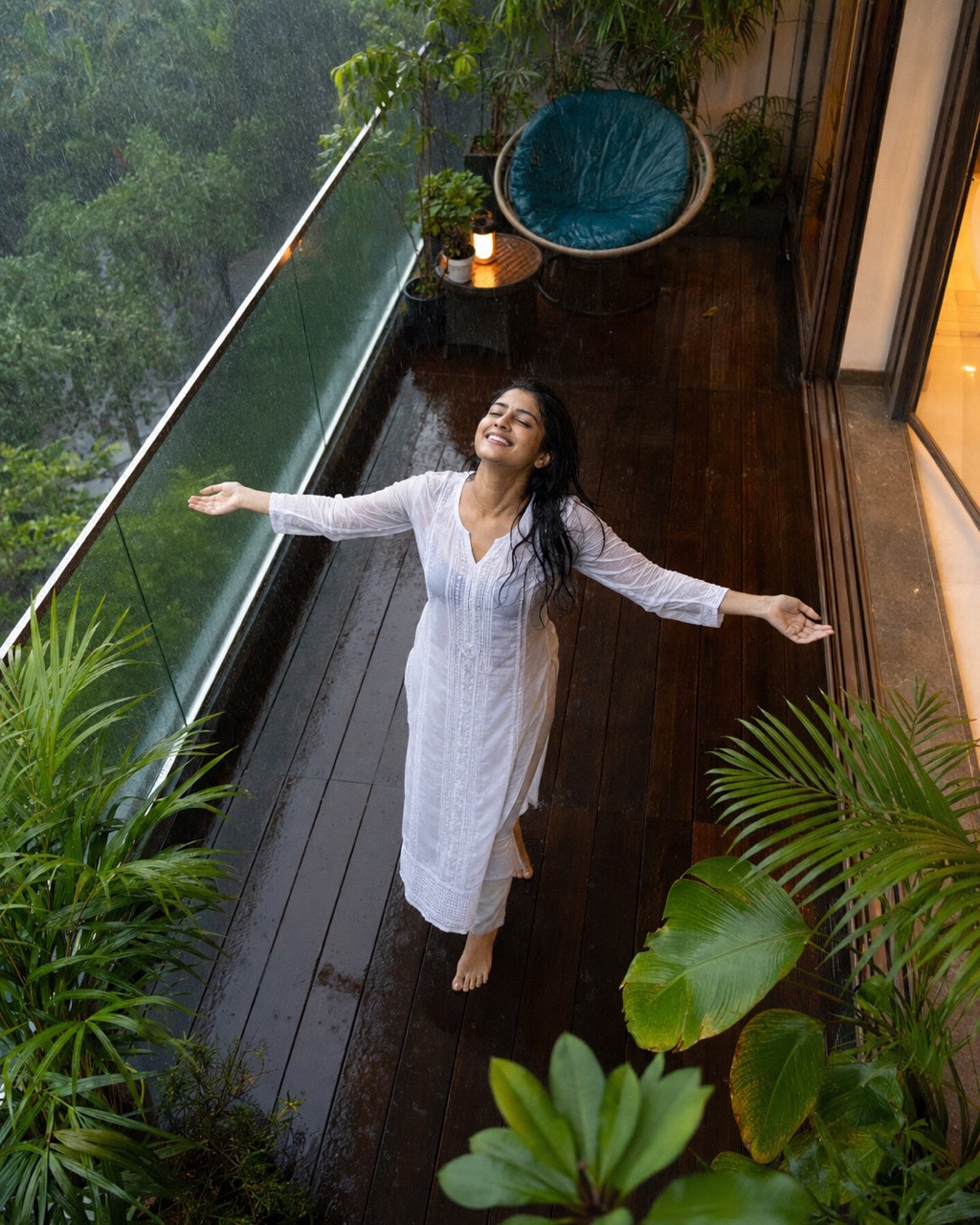 Peaceful Woman Enjoying Monsoon Rain on Balcony | Royalty-Free image | Pixlaris