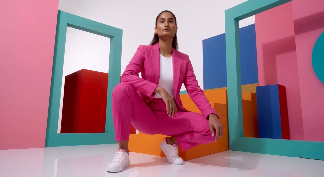 Low Angle Crouching Pose of Woman in Pink Suit | Royalty-Free image | Pixlaris