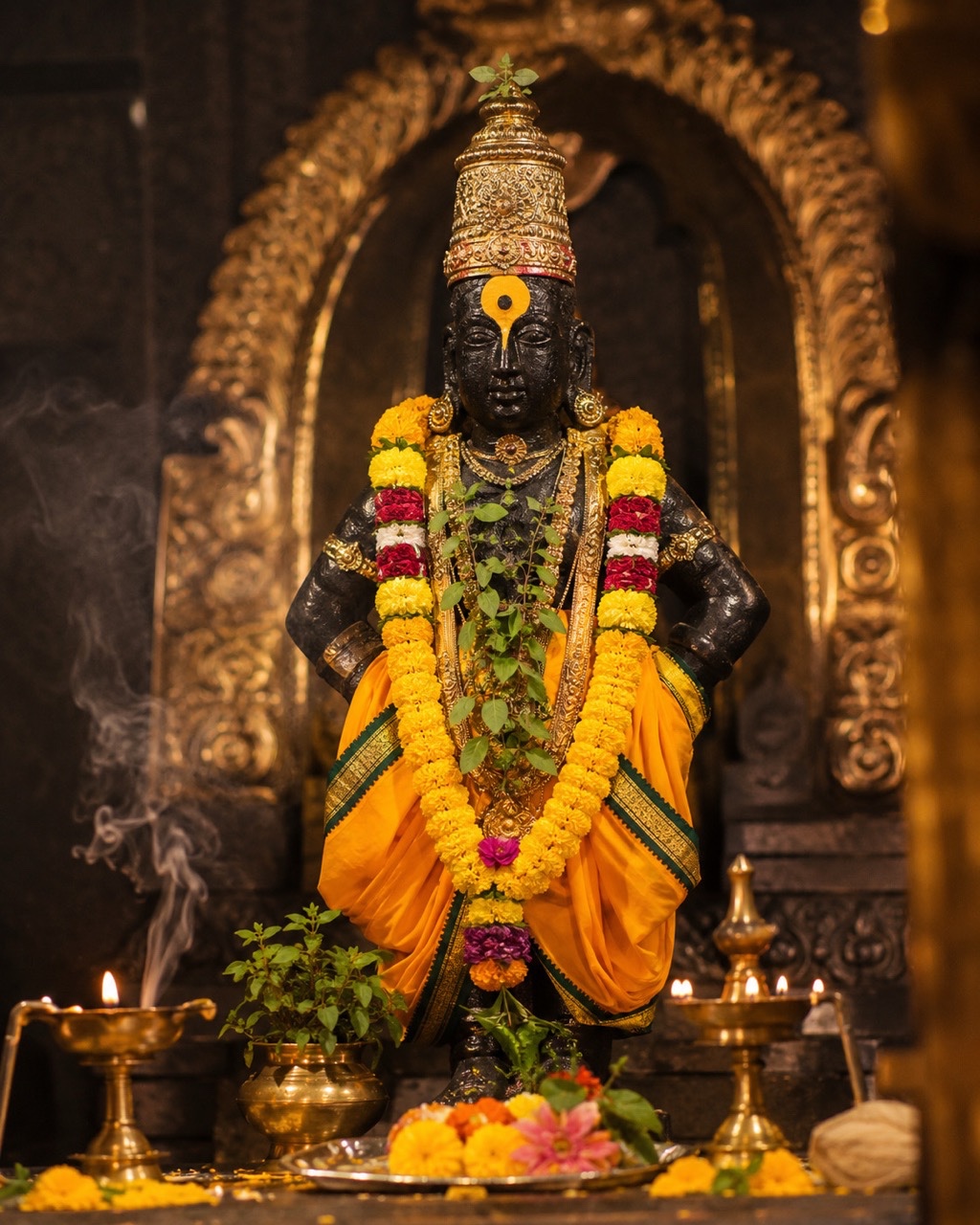 Lord Vitthal Idol Decorated with Yellow Flower Garland in Golden Shrine | Royalty-Free image | Pixlaris